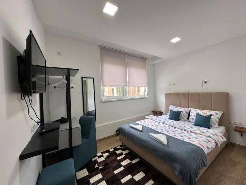 a bedroom with a bed and a television in it at Ravne Energy Apartments in Visoko