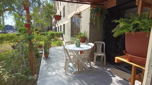 a patio with a table and chairs and plants at Mini Apartamento Vista Verde in Lima