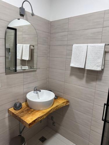 bagno con lavandino, specchio e asciugamani di Ravne Energy Apartments a Visoko