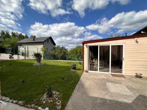 a house with a yard with a sliding glass door at Ravne Energy Apartments in Visoko