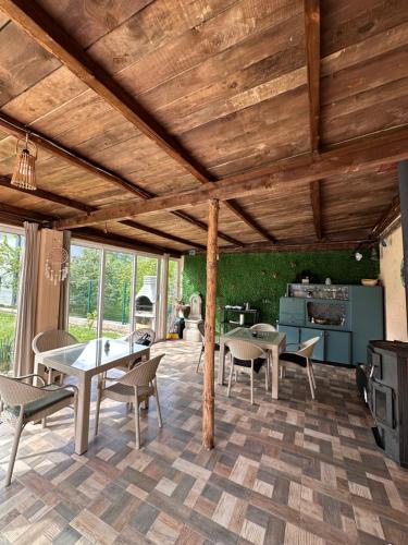 a living room with a wooden ceiling and a table and chairs at Ravne Energy Apartments in Visoko