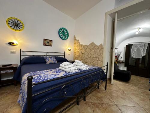Un dormitorio con una cama azul con toallas. en Del Centro, en Enna
