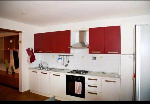 a kitchen with red cabinets and a stove at Camiremare in Portovenere