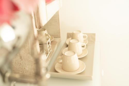 a row of cups and saucers on a shelf at B&B Sweet Home - Cilento in Agropoli