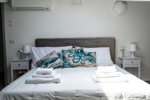 a white bed with pillows and towels on it at B&B Sweet Home - Cilento in Agropoli