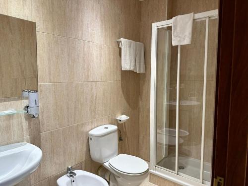 a bathroom with a toilet and a glass shower at Hotel Sancho in Hospitalet de l'Infant