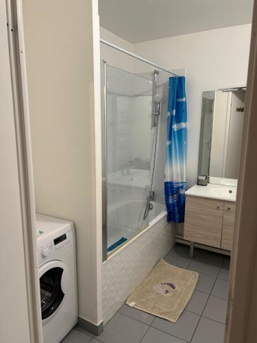 a bathroom with a shower and a washing machine at 5 mn Stade de France in Saint-Denis