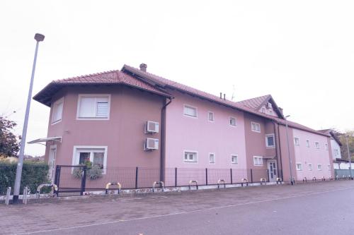 a large pink building on the side of a street at Apartmani Jastreb 2 in Jastrebarsko