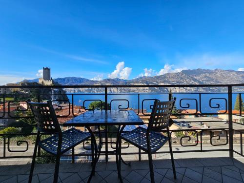 a table and chairs on a balcony with a view of the water at Casa Guarnati Lake View Apartments in Malcesine