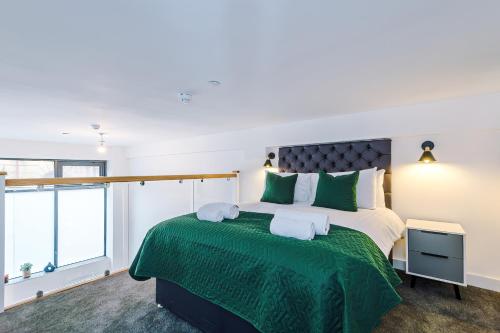 1 dormitorio con 1 cama grande con colcha verde en Silver Street by Staycay, en Bury