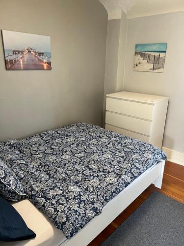 a small bedroom with a bed and a dresser at Homestay in cozy River Heights home in Winnipeg