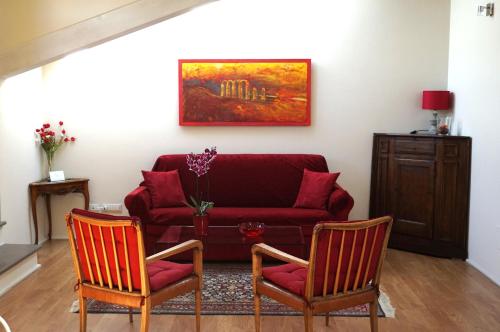 a living room with a red couch and two chairs at Casa Pisterna in Acqui Terme