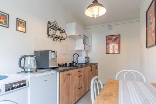 オシフィエンチムにあるSKY Apartment 1の冷蔵庫と椅子付きのテーブルがあるキッチン