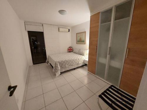 um pequeno quarto com uma cama e um closet em Cobertura ideal pra família toda! no Rio de Janeiro