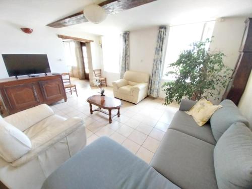 un salon avec un canapé et une télévision dans l'établissement Entre forêts et prairies, à Le Cercueil