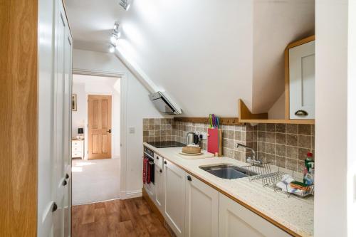 uma cozinha com um lavatório e uma bancada em The Loft em Mickleton