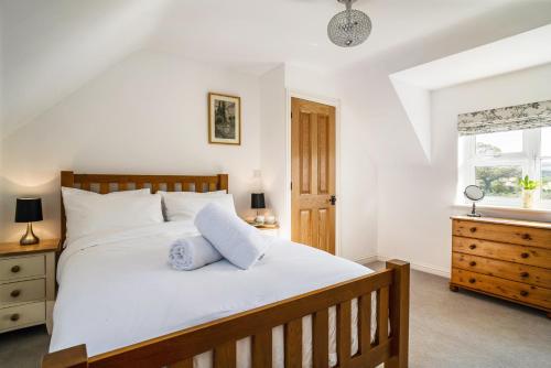 Un dormitorio con una gran cama blanca y una ventana en The Loft, en Mickleton