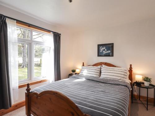 a bedroom with a large bed and a window at Chalet C in Dornoch