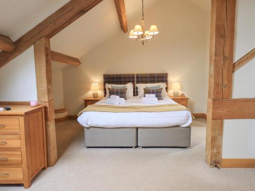 ein Schlafzimmer mit einem großen Bett im Dachgeschoss in der Unterkunft Yew Cottage in Backbarrow