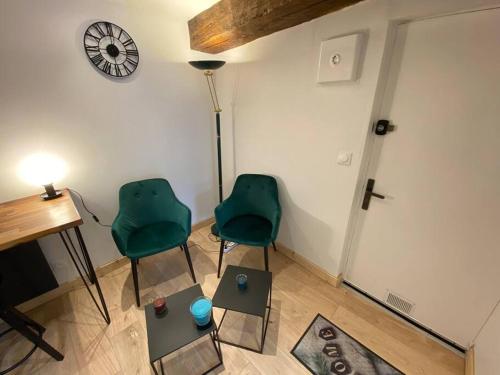 - deux chaises vertes assises dans une pièce avec un piano dans l'établissement Studio cœur de ville historique, à Saint-Brieuc