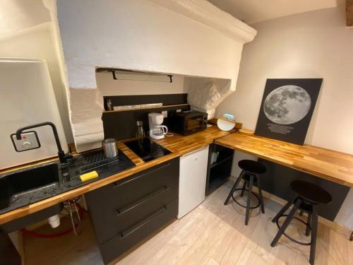 - une cuisine avec un comptoir et deux tabourets dans l'établissement Studio cœur de ville historique, à Saint-Brieuc