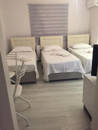 ein Zimmer mit 2 Betten und einem Stuhl darin in der Unterkunft Taksim Cihangir otel in Istanbul