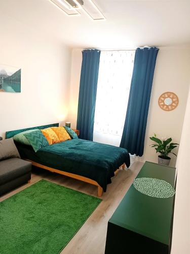 a bedroom with a bed with blue curtains and a green rug at Family Apartment With kitchen Neunkirchen - Apartment 6 in Neunkirchen