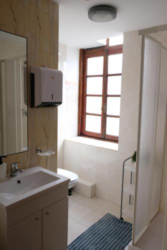 a bathroom with a sink and a toilet and a window at Yellow Inn Aveiro in Aveiro