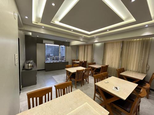 a restaurant with tables and chairs and a kitchen at Hotel Holiday Icon in Dwarka