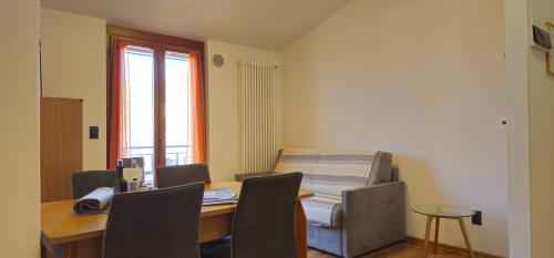 a room with a table and a bed and a table and chairs at Casa Guarnati Lake View Apartments in Malcesine