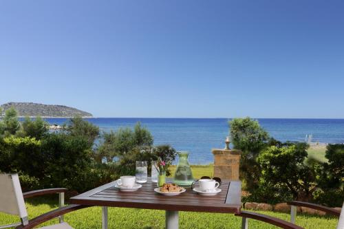 a wooden table with food and a view of the ocean at Artina in Marathopolis