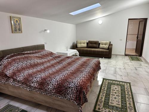 um quarto com uma cama e um sofá em Casa Rustica Cernica em Cernica