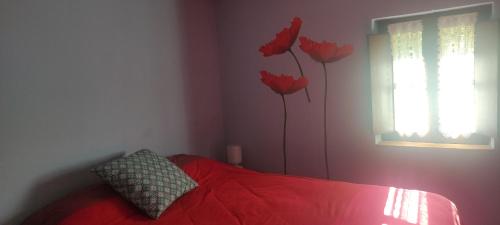 um quarto com uma cama vermelha com flores vermelhas pintadas na parede em EL HORREO em Pesaguero-La Parte