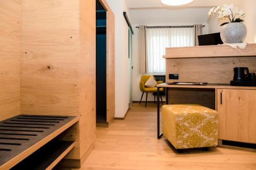 a room with a bed and a desk with a yellow stool at Altstadt-Hotel in Freiberg