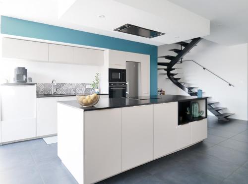 une cuisine avec des placards blancs et un escalier dans l'établissement Grande maison avec piscine, proche océan, Les Sables, 6 personnes, à Les Sables-dʼOlonne