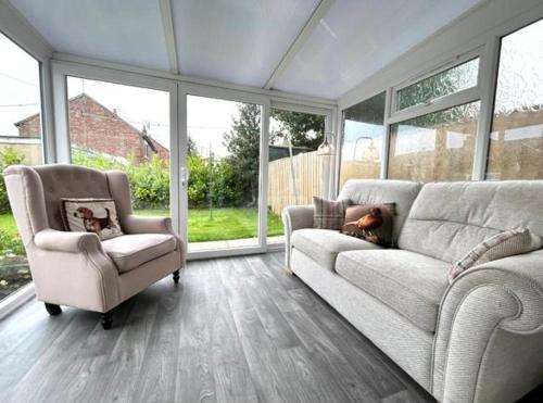 ein Wohnzimmer mit einem Sofa und einem Stuhl in der Unterkunft The Hidden Snug cottage in Knaresborough