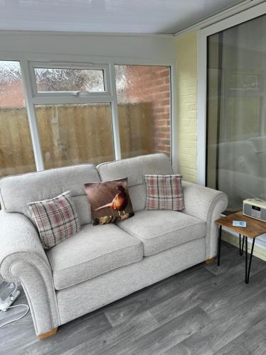 ein Sofa mit zwei Kissen darauf im Wohnzimmer in der Unterkunft The Hidden Snug cottage in Knaresborough