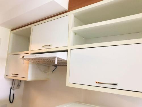 a white kitchen with white cabinets at OZPED Flats Particulares Edifício Life Resort in Brasilia