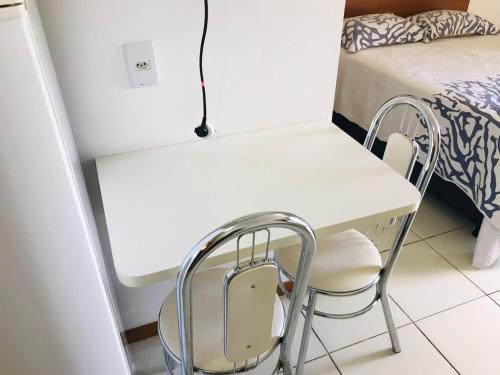 a white table and chairs in a room with a bed at OZPED Flats Particulares Edifício Life Resort in Brasilia