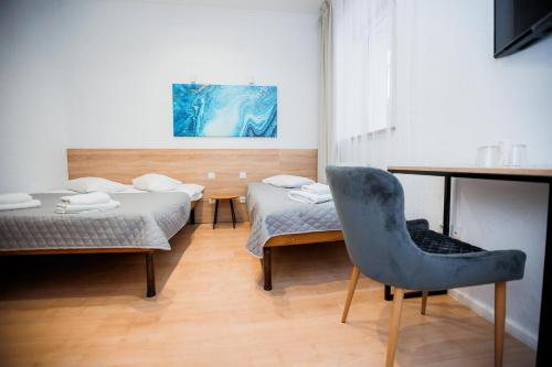 a room with two beds and a desk and a chair at Staryi Krakiv in Lviv