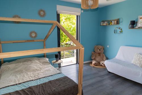 una camera da letto con pareti blu, un letto a castello e un divano di Villa Confortable en Ardèche a Vesseaux