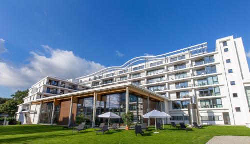 um edifício com cadeiras e guarda-sóis em frente em Carat Apartments Grömitz em Grömitz