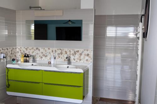 bagno con mobile verde e lavandino di Villa Confortable en Ardèche a Vesseaux
