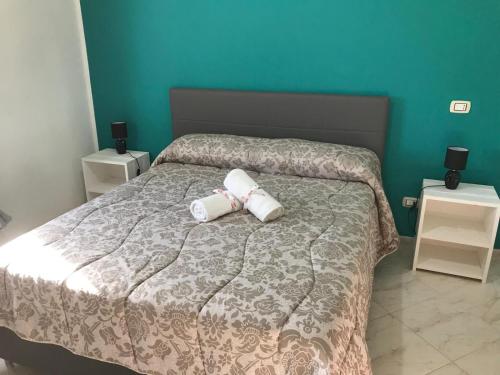 uma cama com duas toalhas enroladas em Villa "Ma Mi" Carloforte em Carloforte