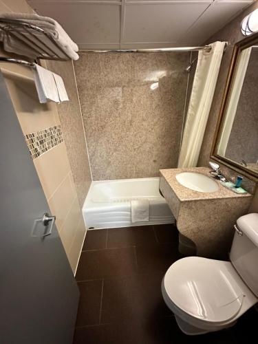 a small bathroom with a toilet and a sink at Town House Inn and Suites in Elmwood Park