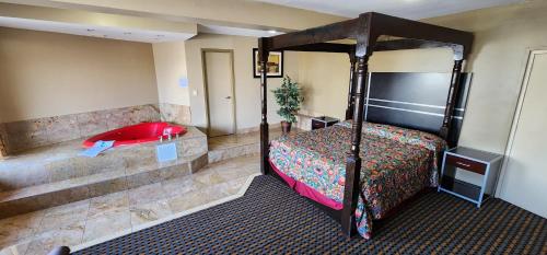 Town House Inn and Suites في إلموود بارك: غرفة في الفندق مع سرير وحوض استحمام