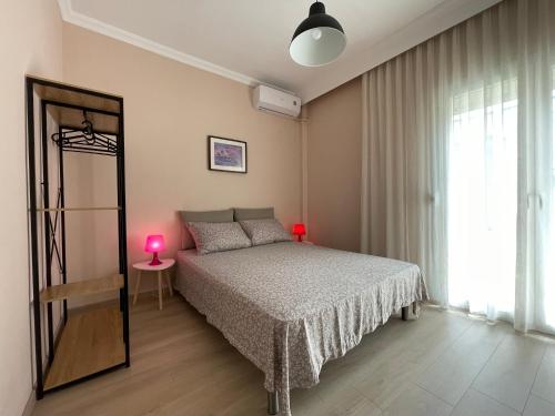 een slaapkamer met een bed, een spiegel en een raam bij Asterios Home in Thessaloniki