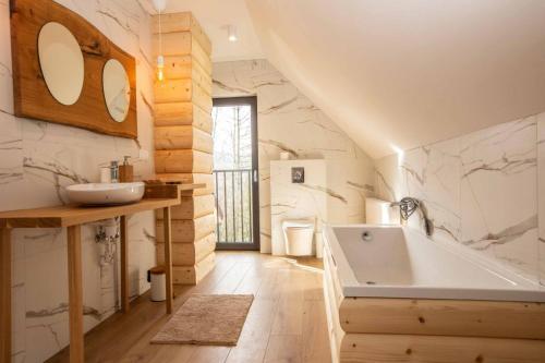 a bathroom with a sink and a tub at Gorczański dom z bali w górach in Poręba Wielka