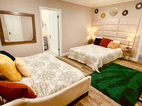 a bedroom with two beds and a green rug at Los Angeles Dream Cottage in Los Angeles