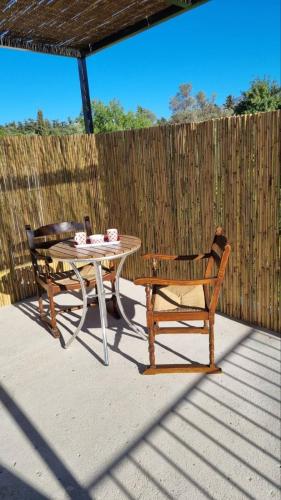 a table and chairs on a patio with a fence at Traditional Anna's Stone House with Private Pool in Margarítai